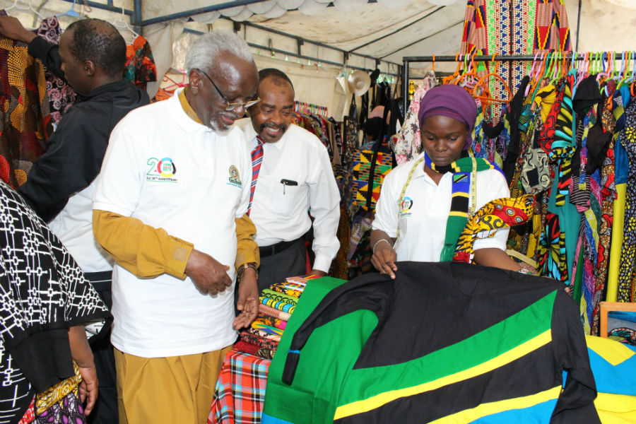 Uganda's 2nd Deputy Prime Minister and Minister for EAC Affairs, Hon. Dr. Ali Kirunda Kivejinja (in glasses) in discussions with a merchant at the trade pavilion during the 20th Anniversary celebrations at the EAC Headquarters.