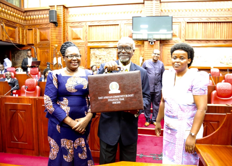 he Chair of the EAC Council of Ministers, Hon Dr Ali Kirunda Kivenjija holds aloft the Budget briefcase.  He is flanked by the Deputy Minister for Foreign Affairs and EAC Co-operation, United Republic of Tanzania, Hon Dr Susan Kolimba and the Minister of EAC Affairs, Burundi, Hon Isabella Ndahayo.