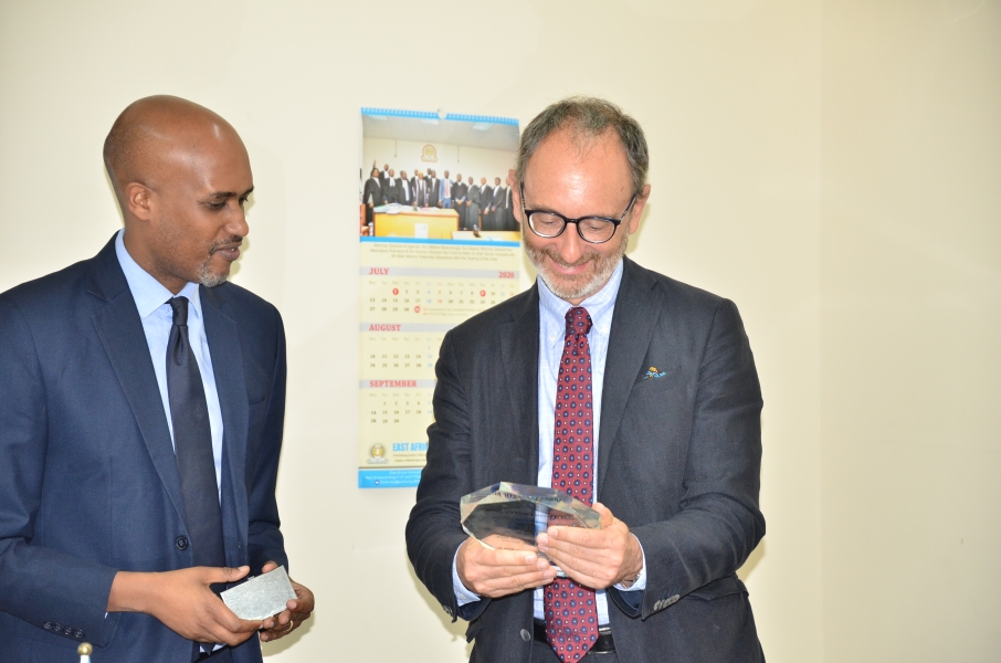 H. E The Ambassador (R) receives a token from the President of the Court (L)